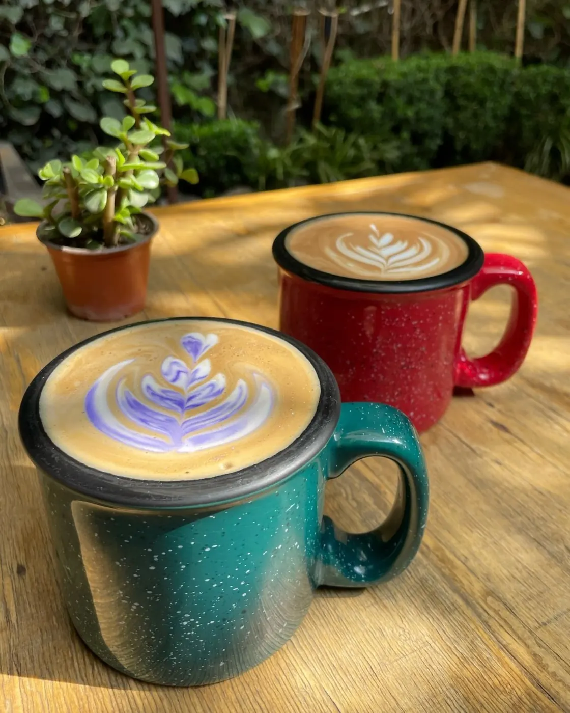 Tazas de peltre roja y verde con arte latte