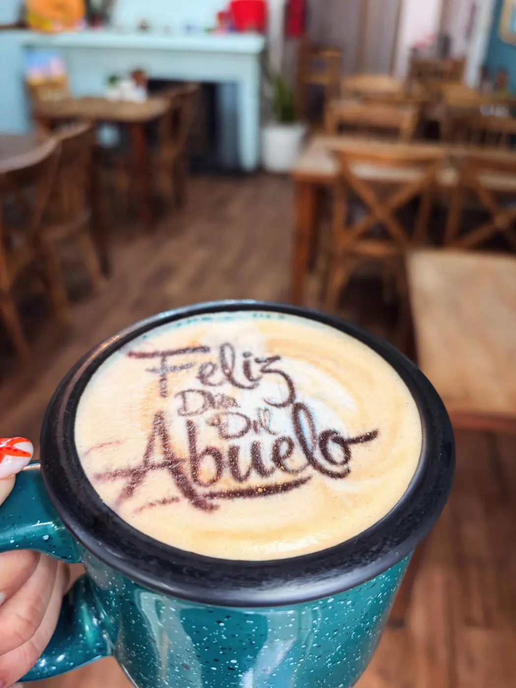 Taza de peltre azul con el mensaje Feliz día del abuelo en la espuma
